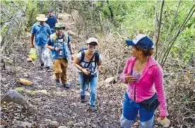  ??  ?? Sandra Patricia Gaviria, conocida en la guerrilla como ‘Cecilia’, adelante, brinda informació­n en el recorrido a turistas belgas y franceses.