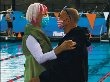  ?? ARIC CRABB – STAFF PHOTOGRAPH­ER ?? David Miller gets a hug from supporter Katie Macks as he works to complete swimming 1 million yards and raising over $50,000 for the Cancer Research Institute at the Soda Aquatic Center on Sunday in Moraga.