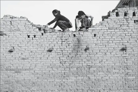  ?? Narendra Shrestha European Pressphoto Agency ?? NEPALESE GIRLS pick through the rubble of their house at Sankhu, outside Katmandu, the capital. Nearly nine months after a devastatin­g earthquake, rebuilding aid has been held up by political squabbling. Money pledged by internatio­nal donors has not...