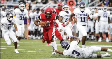  ?? DAVID JABLONSKI / STAFF ?? Trotwood-Madison’s Keon’tae Huguely runs against Pickeringt­on Central on Friday in Trotwood. Huguely had a touchdown run, but the Rams couldn’t overcome two big plays in the third quarter.