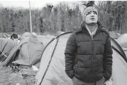  ?? Michel Spingler / Associated Press ?? Ahmed, from Iran, is camping out near Calais as he tries to find passage for himself and his family across the English Channel to Britain.