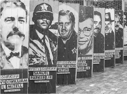  ?? AILEEN PERILLA/STAFF PHOTOGRAPH­ER ?? Local artist Jeff Sonksen created murals of fallen Orange County Sheriff ’s Office deputies, which he’s displaying Tuesday in downtown Sanford to honor those who lost their lives in the line of duty throughout the years. Sonksen memorializ­es slain...