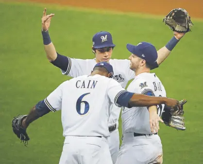  ?? Charlie Riedel, The Associated Press ?? The Milwaukee Brewers’ Lorenzo Cain, Christian Yelich and Ryan Braun, right, celebrate after winning Game 6 of the NLCS against the Los Angeles Dodgers on Friday night. Game 7 is Saturday night.