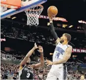  ?? SAM GREENWOOD/GETTY ?? Orlando’s D.J. Augustin attempts a shot over Quincy Pondexter (3) of the San Antonio Spurs in Friday night’s game.