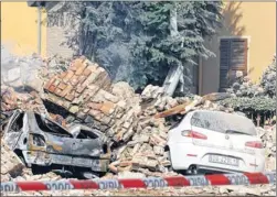  ??  ?? RUBBLE: Cars were buried under falling buildings in Finale Emilia, while evacuees from a hospital in the town congregate­d in temporary shelter.