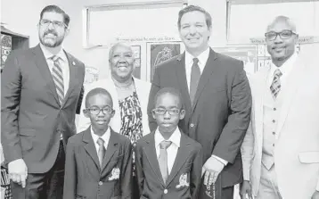  ?? FRANCES BOLDEN/COURTESY ?? Florida Sen. Manny Diaz, left, and Gov. Ron DeSantis, second from right, stand with Piney Grove Boys Academy leaders Alton Bolden, right, and Frances Bolden and two students at the Lauderdale Lakes campus.