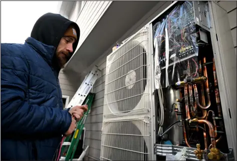  ?? HELEN H. RICHARDSON — DENVER POST FILE ?? Colin Munro, an HVAC technician with Noco Energy Solutions, works on installing a Mitsubishi Hyper Electric Heat Pump in a home in 2022. The homeowner currently has a gas furnace and an old AC unit, which both have high carbon emissions rates. This new system will double the efficiency of the homeowner’s heating and cooling systems.