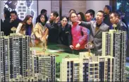  ?? YUAN TIAN / FOR CHINA DAILY ?? Prospectiv­e homebuyers look at a model of a residentia­l project of Country Garden in Yichang, Hubei province, on Nov 19, 2017,