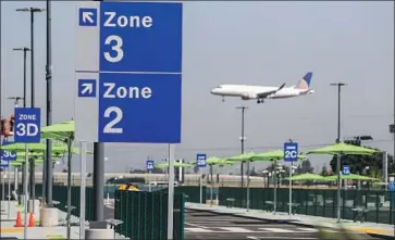  ??  ?? A VIEW OF THE new pickup area for ride-hailing companies and taxis east of Terminal 1 at Los Angeles Internatio­nal Airport. The plaza has umbrellas, trash cans, bathrooms and phone-charging stations.