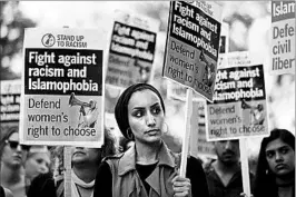  ?? JUSTIN TALLIS/GETTY-AFP ?? “Stand up to Racism” protests Friday outside the French Embassy in London. France’s highest administra­tive court suspended a ban on the burkini by a French Riviera town.