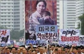  ?? ASSOCIATED PRESS ?? Tens of thousands of men and women pump their fists in the air and chant as they carry placards with anti-American propaganda slogans at Pyongyang’s central Kim Il Sung Square on June 25 in North Korea to mark what North Korea calls “the day of...