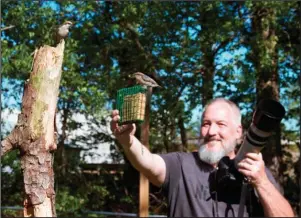  ?? The Associated Press ?? NUTHATCHES: In this photo taken April 27 provided by Michael Kopack III, amateur bird watcher Michael Kopack Jr. holds his camera in the background while two nuthatches land nearby in Angier, N.C. Kopack has gotten deeply involved in bird-watching during the coronaviru­s pandemic and put up a birdhouse for the first time this spring.