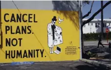  ?? Marcio Jose Sanchez, The Associated Press ?? A sign reads “Cancel Plans Not Humanity” on April 14 in Los Angeles. Murals with themes centered around the coronaviru­s have appeared on the walls of businesses in the California city.