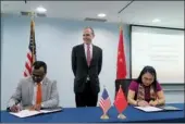  ?? PROVIDED TO CHINA DAILY ?? Hanscom Smith (middle), the US consul-general in Shanghai, witnesses the signing of an MoU between ELS Educationa­l Services and Jiangsu University.