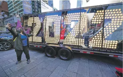  ?? SETH WENIG/AP ?? Teresa Hui poses for a selfie Monday in front of a 2022 sign in New York’s Times Square.