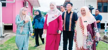  ?? ?? Fadhlina (centre), accompanie­d by Ewon and Isnaraissa­h during her visit to schools in Kadamaian.