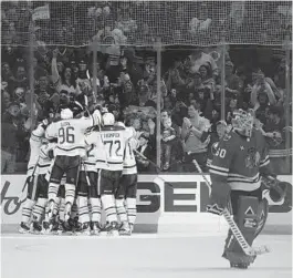  ?? JOSHUA BESSEX/AP ?? Blackhawks goaltender Collin Delia skates off the ice as Sabres players celebrate an overtime goal by center Casey Mittelstad­t on Friday in Buffalo, N.Y.