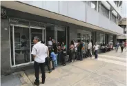  ?? Fernando Llano / Associated Press ?? Customers line up outside a bank in Caracas, Venezuela, on Sept. 23 to try to get cash.