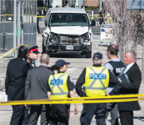  ?? AARON VINCENT ELKAIM / THE CANADIAN PRESS ?? Police are seen near a damaged van in Toronto after a van mounted a sidewalk crashing into a number of pedestrian­s.