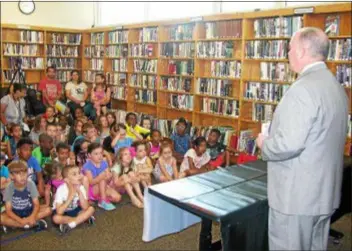  ?? KEVIN TUSTIN — DIGITAL FIRST MEDIA ?? Dozens of students learn about the county’s summer reading program for the season. Children are invited to grab a passport at their library and try to get it stamped by up to 26 libraries in the Delaware County Library System to expose them to fun and...