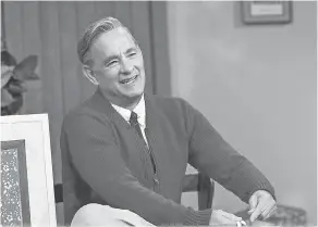  ??  ?? Tom Hanks dons the red cardigan and comfy sneakers of the iconic Mister Rogers in “A Beautiful Day in the Neighborho­od.”