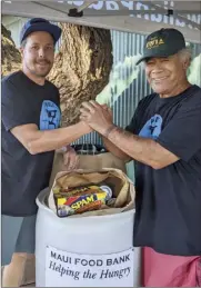  ?? ?? Kihei Canoe Club member Kimokeo Kapahulehu­a (right) and Hawaiian Paddle Sports owner Timothy Lara stand by a bin overflowin­g with food donations for the Maui Food Bank on Thanksgivi­ng morning.