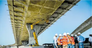  ?? FOTOS CÉSAR BOLÍVAR ?? El grupo de expertos observa a los obreros que reparan las “fisuras” en el tablero del Puente Pumarejo.