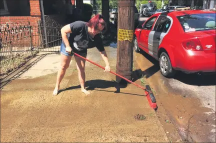  ?? EVAN BRANDT — MEDIANEWS GROUP ?? Andrea Bray brushes mud off the sidewalk in front of her Walnut Street home Wednesday. The region experience­d serious flooding Tuesday in the wake of Tropical Storm Isaias.