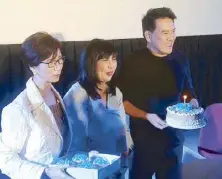  ??  ?? The award-winning director is surprised with a birthday cake by TV5 and SM executives