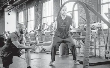  ?? Pete Marovich photos / Washington Post ?? Suhaib Webb, right, works out with his personal trainer, Garrett Thomas, at a Washington, D.C., gym.