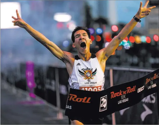  ?? Joel Angel Juarez ?? Las Vegas Review-journal @jajuarezph­oto Matthew Liaw crosses the finish line as the winner of the 10K men’s run at the Rock ‘n’ Roll Marathon along the Strip near The Mirage on Sunday.