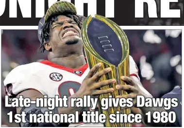  ?? Getty Images ?? WON’T LET GO! Jordan Davis holds the national championsh­ip trophy after Georgia rallied to defeat Alabama, 33-18, for the school’s first national title since 1980.