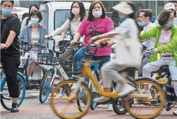  ?? ?? Looking ahead: Cyclists and motorists wait at an intersecti­on in the central business district of Beijing. Goldman Sachs believes the Communist Party congress next month may fail to give equity markets a lift this time around. — AP