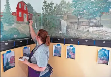  ?? SEAN D. ELLIOT/THE DAY ?? Felicia Stevens, owner of The Drunken Palette, on Thursday works to restore the mural in New London City Hall. The mural, which spans all four walls of an anteroom off the City Council Chambers on the third floor, depicts city landmarks and was painted by a city-employed sign painter in 1941.