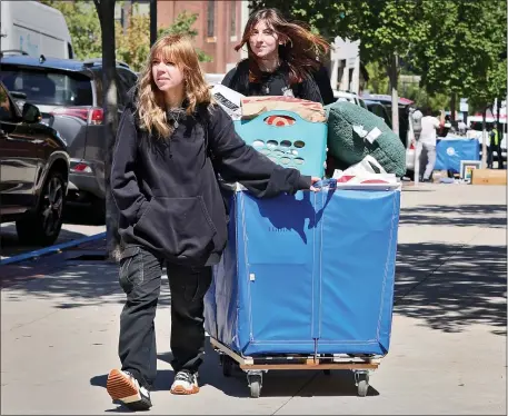  ?? NANCY LANE — BOSTON HERALD ?? Bridget MacDougall and Ella Mott push their things in a laundry cart as students move in at Boston University.