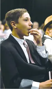  ??  ?? St Paul’s student Oliver Spath enjoys the premiere videos of school musical “Cindy” at the graduation event.