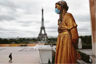  ?? Christophe Ena / Associated Press ?? A statue is adorned with a mask in Paris. France continues to be under an extended stay-at-home order until May 11 in an attempt to slow the spread of the coronaviru­s.