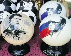  ?? EFREM LUKATSKY / THE ASSOCIATED PRESS ?? Wooden balls depicting Russian President Vladimir Putin and soccer star Cristiano Ronaldo are popular souvenirs in Russia.