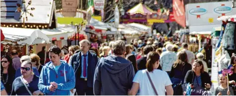  ??  ?? Das Wetter passt und treibt die Menschen aus dem Haus – zum Beispiel auf die Dult. Auf dem Jahrmarkt flanieren die Augsburger, um Waren zu kaufen. Manchen erinnern sich aber auch einfach gerne an alte Zeiten zurück.