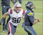  ?? AP FILE ?? Patriots defensive lineman Chase Winovich closes in on Seahawks quarterbac­k Russell Wilson last Sunday.