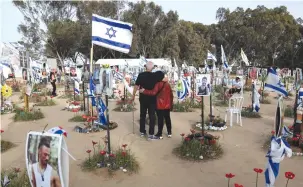  ?? (Ronen Zvulun/Reuters) ?? A COUPLE VISIT the site of the Supernova music festival yesterday where Hamas terrorists killed, maimed and kidnapped hundreds of revelers during the October 7 rampage.