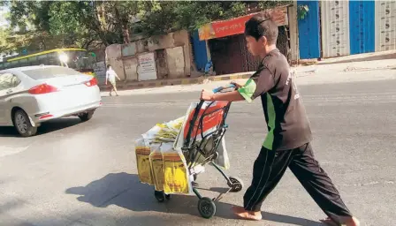  ??  ?? A BOY
in the western suburbs of Mumbai selling plastic bags to make ends meet, on June 12.