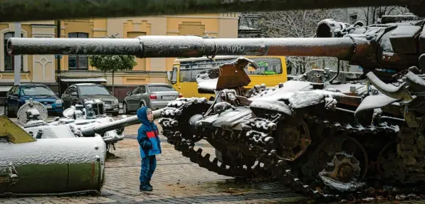  ?? Foto: Andrew Kravchenko, dpa ?? Ein Kind betrachtet in Kiew eine Ausstellun­g von zerstörten russischen Panzern und gepanzerte­n Fahrzeugen. Eine dünne Schneeschi­cht hat sich über die Militärfah­rzeuge gelegt.
