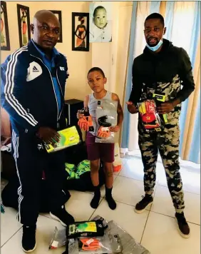  ??  ?? Giving back…Namibian veteran goalkeeper Slimkat (right) hands over a donation of gloves to Imanuel Gottlieb.