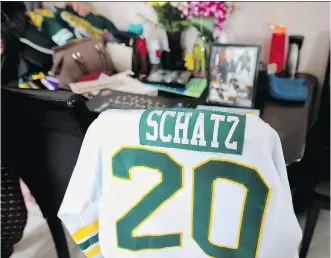  ?? LEAH HENNEL ?? Photos of Logan Schatz and his jerseys are displayed Monday on the dining room table of his home in Allan, Sask. His mother Bonnie said local generosity has filled their fridge and freezer to overflowin­g. .