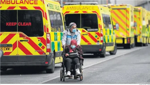  ?? ANDY RAIN / EFE ?? Un hombre empuja la silla de ruedas ayer rodeado de ambulancia­s en el hospital Royal London de la capital británica.