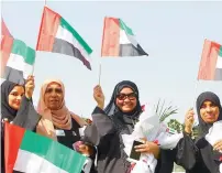  ?? Photo by Juidin Bernarrd ?? Women greet each other with national flags at the Community Developmen­t Authority in Dubai.—