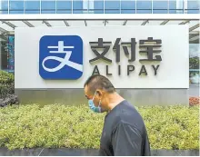  ?? AFP-Yonhap ?? A pedestrian walks past an Alipay logo at the Shanghai office building of Ant Group in this 2020 photo.