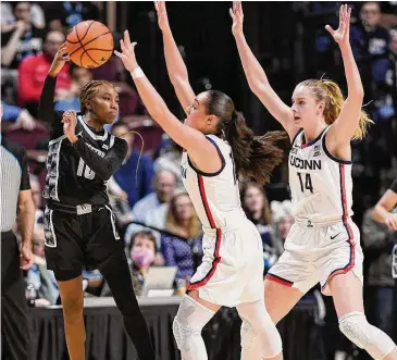  ?? Jessica Hill/Associated Press ?? Georgetown’s Kennedy Fauntleroy (10) passes under pressure from UConn’s Nika Muhl and Dorka Juhasz (14) during the first half on Saturday.