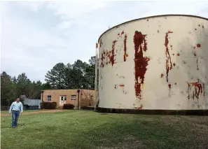  ?? (Photo by Neil Abeles) ?? Hughes Springs City Manager Stephen Barnes is walking by one of the city’s two ground storage tanks, this one currently not being used. New to come at left, however, is the system’s pump house which will be replaced along with two new pumps.